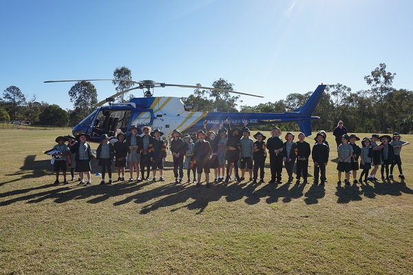 Our students in front of helicopter on school oval